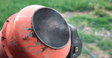 Eski turuncu çimento karıştırıcısında kuru beton ve açık hava inşaat malzemeleri var.
