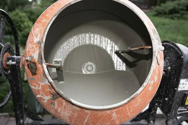 Eski turuncu çimento karıştırıcısında kuru beton ve açık hava inşaat malzemeleri var.