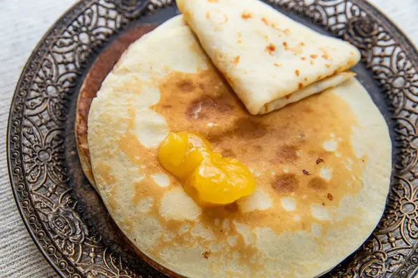 Üstünde tereyağı eriyen sıcak altın krepler. Eski tarz tabakta servis edilen ev yapımı yemekler. Kahvaltı, rahat mutfak sahneleri ve mutfak temaları için mükemmel..