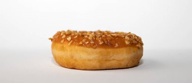 Beyaz arka planda ezilmiş fındıklı karamel çöreğin yakın çekimi. Tatlı tatlı atıştırmalık, fırın reklamları, fast food menüsü ve hamur temalı içerik için mükemmel..