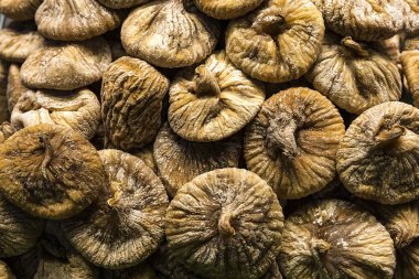 Doğal dokusu ve şekerli yüzeyi olan organik kurutulmuş incir. Sağlıklı yiyecekler, vejetaryen atıştırmalıklar, doğal tatlılar ve geleneksel beslenme temaları için ideal..