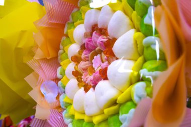 Jöleli şeker ve kırmızı meyan kökü karışımı berrak bir şeker kutusunda. Şeker dükkanları, çocuk etkinlikleri veya şekerleme temaları için ideal.