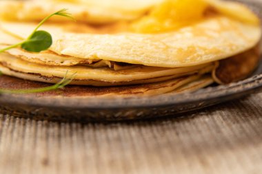 Bir kaşık dolusu kayısı reçelli altın krep detaylarıyla. Yumuşak dokuları ve sıcak tonlarıyla tatlı tatlı konsepti.