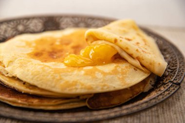 Üstünde altın bal olan ince ev yapımı krep yığını. Sıcak ve iştah açıcı tatlı, kahvaltı ya da kahvaltı için mükemmel..