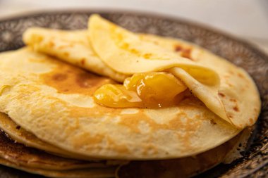 Üstünde altın bal olan ince ev yapımı krep yığını. Sıcak ve iştah açıcı tatlı, kahvaltı ya da kahvaltı için mükemmel..