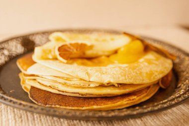 Kurutulmuş portakal dilimi ve altın kayısı reçeli ile servis edilen kırsal krep yığını. Kahvaltıda, kahvaltıda, kahvaltıda ya da atıştırmalıkta sıcak ev yapımı tatlı..