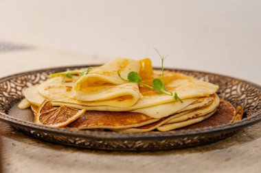 Kurutulmuş portakal dilimi ve altın kayısı reçeli ile servis edilen kırsal krep yığını. Kahvaltıda, kahvaltıda, kahvaltıda ya da atıştırmalıkta sıcak ev yapımı tatlı..