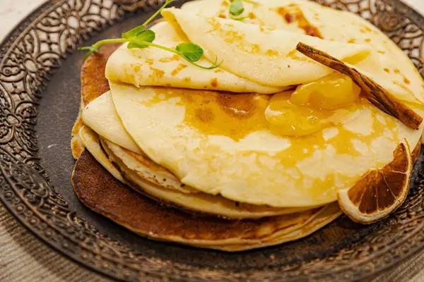 Kurutulmuş portakal dilimi ve altın kayısı reçeli ile servis edilen kırsal krep yığını. Kahvaltıda, kahvaltıda, kahvaltıda ya da atıştırmalıkta sıcak ev yapımı tatlı..