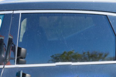 Toz, leke ve su izleriyle dolu kirli bir araba yüzeyine yakın plan. Araba yıkama hizmetleri, self servis yıkama istasyonları veya araçlar için reklam temizleme ürünleri için ideal.
