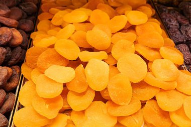 Parlak kurumuş kayısılar bir yığın halinde dizilmiş. Vitamin ve lif açısından zengin sağlıklı bir atıştırmalık. Yemek ve tatlılarda popüler kurutulmuş meyve..