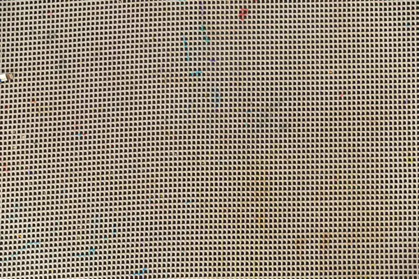 Kirli kauçuk şebeke paspasının, görünür deliklerin ve renkli parçacıkların makro dokusu. Arkaplan, endüstriyel dokular, onarım veya donanım ve araçlarla ilgili tasarımlar için ideal.