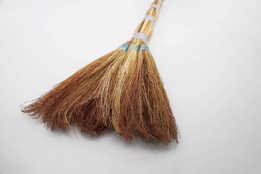 Beyaz arka planda duran tahta saplı saman süpürgesi, yan görüş. Ev ve bahçe için çevre dostu el yapımı temizlik aracı.