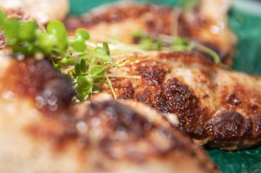 Sulu ızgara tavuk, altın rengi çıtır deri ve taze mikro yeşillikler. Lezzetli ev yemeği konsepti..