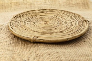 Çuval bezinde yuvarlak hasır tabak, yemek servisi ve tasarım için kırsal eko mutfak dekorasyonu, doğal el yapımı aksesuar.