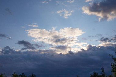 Akşam gökyüzü dramatik bulutlar ve güneş ışığı, huzurlu günbatımı manzarası, doğa anlayışı arka plan ve hava durumu.