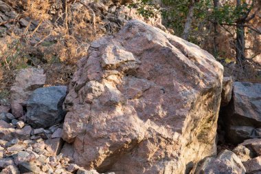 Sıcak gri ve turuncu tonlara sahip doğal bir taş yüzeyinin yakın çekimi, arka plan, doku ve tasarım elementleri için idealdir..