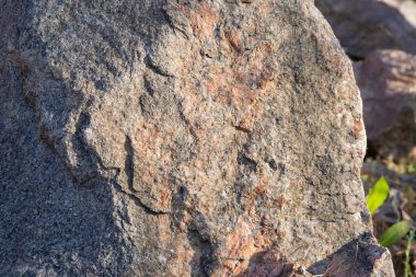 Sıcak gri ve turuncu tonlara sahip doğal bir taş yüzeyinin yakın çekimi, arka plan, doku ve tasarım elementleri için idealdir..