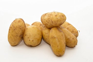 Beyaz arka planda yıkanmamış taze organik patatesler yığını. Sağlıklı gıda, tarım hasadı, tarım ve yemek malzemeleri temaları için yakın çekim.