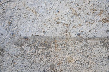 Çizikler, çatlaklar ve pürüzlü yüzeyli gri beton duvar dokusu. Arkaplan, grunge tasarımları ve inşaat temaları için ideal.