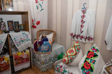10 Temmuz 2025 'te Poltava' da bir halk sanatları sergisinde nakışlı vyshyvanka gömlekleri, çiçek yastıkları, boyalı keten kutular ve hasır ve ahşap sergilenen el işi çarşaflar..