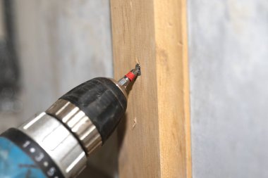  Elektrikli matkap ahşap çivi deliğinde pilot deliği oluşturuyor