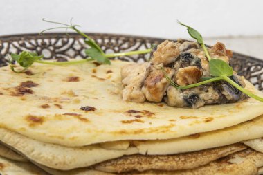 Süslü bir tabağa istiflenmiş, bitkisel ve zeytinli krepler kaldırıldı..