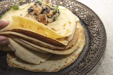 Süslü bir tabağa istiflenmiş, bitkisel ve zeytinli krepler kaldırıldı..