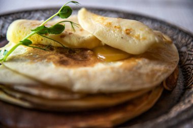 Erimiş tereyağı ve taze bezelyeli süslemeli ince krepler..