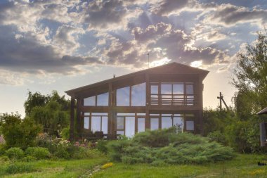 Geniş panoramik pencereli kırsal ahşap bir ev. Uzun vadeli kiralanabilir bahçe. Aile inzivası için mükemmel.
