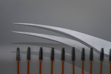 Kirpik ve kaş bakımı için maskara spoolie fırçaları gri arka planda sıralanmış. Makyaj ve kozmetik için güzellik araçları.