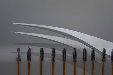 Kirpik ve kaş bakımı için maskara spoolie fırçaları gri arka planda sıralanmış. Makyaj ve kozmetik için güzellik araçları.