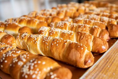 Yumuşak ve yumuşak ev yapımı sosisli börekler, altın kabuklu ve susamlı. Aile yemekleri, piknikler ya da sıcak mutfak anları için mükemmel..