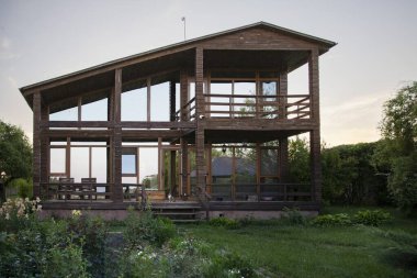 Yeşil bahçedeki panoramik pencereli çağdaş ahşap ev mimarlık ve emlak temaları için mükemmel.