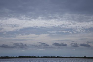 Dramatik bulutlu bir gökyüzü altında manzaralı nehir manzarası, doğa, seyahat ve manzara fotoğrafçılığı temaları için mükemmel.