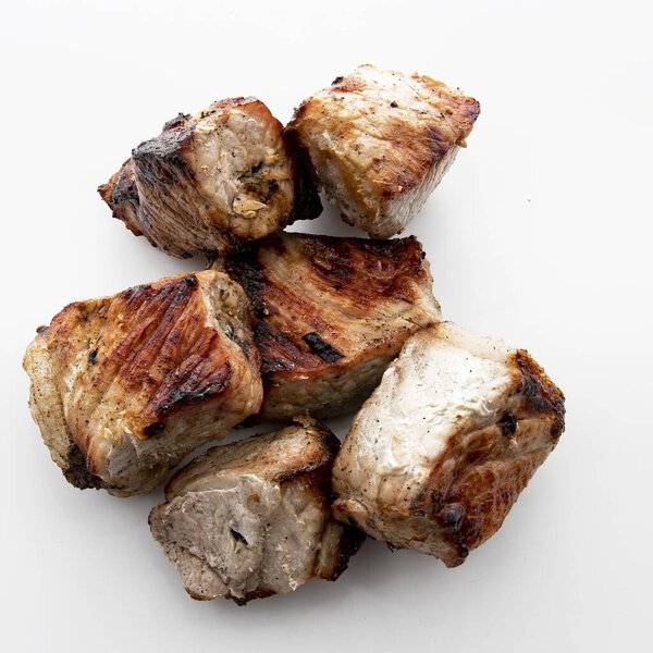Close up of juicy grilled pork shashlik pieces isolated on white background Perfect for barbecue picnic and traditional cuisine themes