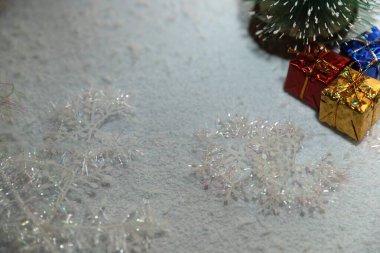 Küçük dekoratif dekoratif kış arkaplanı sunar Noel ağacı ve karlı yüzeyde ışıl ışıl kar taneleri tatil tasarımı için mükemmel