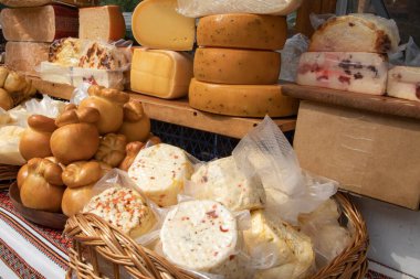 Yerel çiftçi pazarındaki ahşap tezgahta farklı tipte peynir tekerlekleri ve bloklar geleneksel süt ürünleri ve gurme gıda konsepti