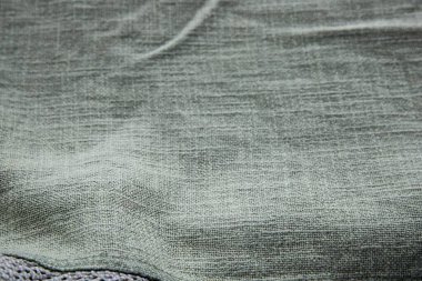 İç tasarım ve zanaat projeleri için yumuşak katlanmış arka planlı yeşil tekstil kumaş dokusunu kapat