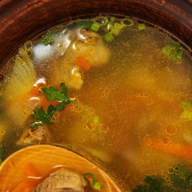 Çamur kasesi sıcak et çorbası sebzeler ve domatesler siyah arka planda izole edilmiş.