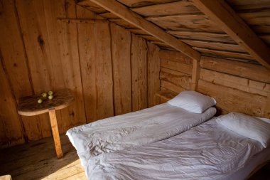Yatak ve beyaz yataklı ahşap kırsal yatak odası rahat kabin Minimalist iç tasarım eko yaşam tarzı kırsal turizm ve doğal rahatlama