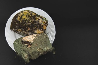 Bozulmuş ekmek tamamen yeşil siyah ve sarı mantarla kaplanmış. Koyu arka plan konsepti olan gıda atıkları, sağlıksız ürün ve zehirli kirlilik üzerine.