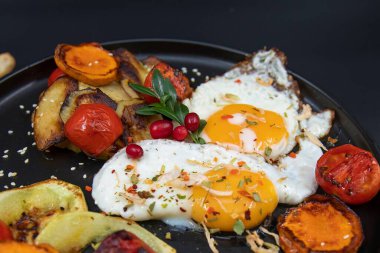 Siyah tabakta taze domatesli yumurta ve sebze. Sağlıklı kahvaltı konsepti.