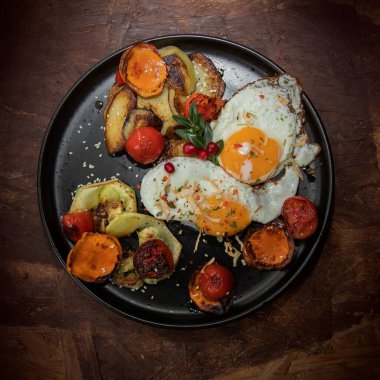 Patates kızartması, kabak ve domatesle servis edilen yumurta sarısı ve ev yapımı sağlıklı ev yapımı kahvaltı konsepti.
