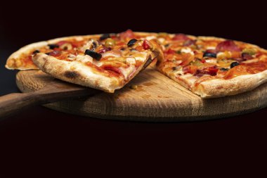 Tahta tahtada erimiş peynir, sosis, zeytin, biber ve soğanlı taze pizza yakın çekim. Restoran menüsü, fast food reklamı, İtalyan mutfağı ve teslimat konsepti için mükemmel..
