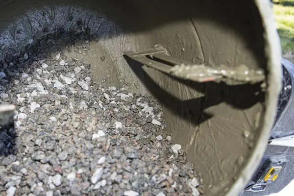 Açık hava inşaat alanında çakıl ve havan ile çimento karıştırıcısına yakın çekim. İnşaat malzemeleri, yenileme çalışmaları, inşaat mühendisliği ve somut hazırlık kavramı.