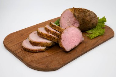 Ahşap bir kesme tahtasının üzerinde marul yapraklarıyla servis edilen baharatlı domuz eti yakın çekim. Ev yapımı yemekler, et yemekleri, yemek pişirme ve geleneksel mutfak kavramı.