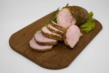 Ahşap bir kesme tahtasının üzerinde marul yapraklarıyla servis edilen baharatlı domuz eti yakın çekim. Ev yapımı yemekler, et yemekleri, yemek pişirme ve geleneksel mutfak kavramı.