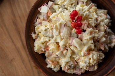 Patates, havuç, turşu, bezelye, yumurta ve mayonez ile yapılan geleneksel Rus Olivier salatasının kapağı garnitürle servis ediliyor. Akşam yemeği veya bayram kutlaması için ev yapımı şenlik yemeği.