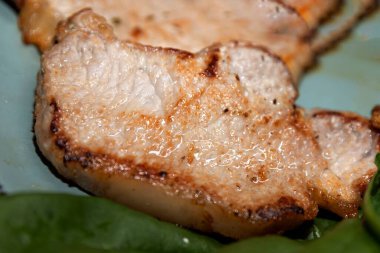 Lezzetli ızgara domuz eti, altın kahverengi kabuklu ve yumuşak dokulu. Ev yapımı yemek, sağlıklı protein yiyeceği ve gurme mutfağı kavramı..