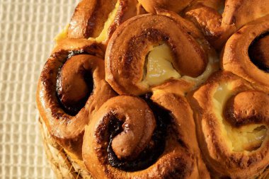 Sıcak ışık altında çikolatalı ve peynirli ev yapımı tatlı böreklerin yakın çekimi. Ev yapımı fırın, tatlı ve geleneksel hamur işi kavramı.